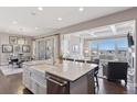 Modern kitchen with granite counters, farmhouse sink, stainless appliances and adjacent living and dining areas at 23635 E Del Norte Pl, Aurora, CO 80016