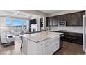 Modern kitchen with granite counters, farmhouse sink, stainless appliances and views into the living room at 23635 E Del Norte Pl, Aurora, CO 80016