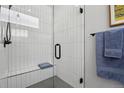 Bathroom features a glass enclosed shower, with vertical tiling and a tiled bench at 1286 Raleigh St, Denver, CO 80204