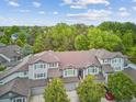 View of townhomes featuring well-maintained gray exteriors, brown roofing, and lush green landscaping at 1441 S Ulster St, Denver, CO 80231