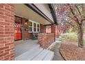 Inviting covered front porch with red brick and painted concrete at 1640 Harrison St, Denver, CO 80206