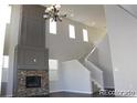Living room boasts soaring ceilings, a stone fireplace, and a chandelier at 15305 W 93Rd Ave, Arvada, CO 80007