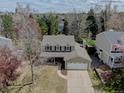 Aerial view of home with green lawn and trees, garage, and covered front porch at 6719 E Costilla Cir, Centennial, CO 80112