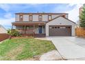 Inviting two-story home featuring a front porch, attached two-car garage, and a well-kept lawn at 4808 S Ward Way, Morrison, CO 80465