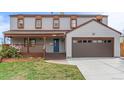Lovely two-story home featuring a covered front porch, a two-car garage, and a manicured front lawn at 4808 S Ward Way, Morrison, CO 80465