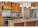 Modern kitchen with granite counters, stainless steel appliances, and custom cabinetry at 1195 W 70Th Ave, Denver, CO 80221