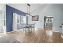 Bright dining area features wood floors, modern lighting, and large windows for natural light at 8815 W Quarto Cir, Littleton, CO 80128