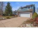 Charming two-story home with brick accents, a large driveway, and landscaped front yard at 8815 W Quarto Cir, Littleton, CO 80128