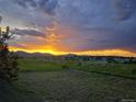 Panoramic sunset view over a green field, showcasing the home's beautiful natural surroundings at 8815 W Quarto Cir, Littleton, CO 80128