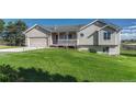 Charming home with well-manicured front lawn and covered porch, enhancing curb appeal at 1166 Belgian Trl, Elizabeth, CO 80107