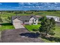 Well maintained front exterior featuring a covered porch, two car garage, and large yard at 1166 Belgian Trl, Elizabeth, CO 80107