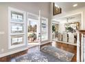 Bright foyer featuring hardwood floors and decorative glass windows with a view into the dining room at 4483 W Cottonwood Pl, Littleton, CO 80123