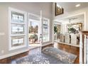 Bright foyer with hardwood floors, decorative rug, and views into the dining room at 4483 W Cottonwood Pl, Littleton, CO 80123