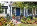 Inviting front entry with a vibrant blue door, surrounded by colorful flowers and plants at 4483 W Cottonwood Pl, Littleton, CO 80123