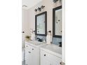 Modern bathroom features double sinks, black fixtures, and stylish mirrors at 3600 S Pierce St # 7-201, Denver, CO 80235