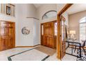 Elegant foyer features a high ceiling, tile flooring, and a beautiful wood door with glass accents at 9754 Las Colinas Dr, Lone Tree, CO 80124