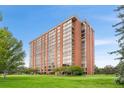 Brick high-rise apartment building featuring manicured lawn at 1900 E Girard Pl # 505, Englewood, CO 80113