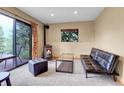 Cozy living room with a wood-burning stove and sliding door to deck and nature at 30273 Conifer Rd, Evergreen, CO 80439