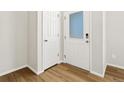 Bright entryway featuring wood-look flooring, white walls, and doors with glass panel at 6531 N Malaya St, Aurora, CO 80019