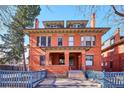 Attractive red brick home featuring a covered front porch and a well-manicured lawn at 1401 N Franklin St # 1, Denver, CO 80218