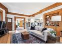 Inviting living room features hardwood floors, wood trim, built-in shelving, and a large, comfortable sofa at 1401 N Franklin St # 1, Denver, CO 80218