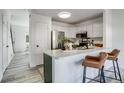 Contemporary kitchen featuring a breakfast bar with seating and stainless steel appliances at 2642 Devonshire Ct, Denver, CO 80229