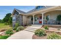 Lovely home entrance with stone accents, landscaped garden beds, and a welcoming front porch at 18376 Heavens Pl, Monument, CO 80132