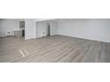 Spacious living room with open floor plan, light gray walls, and durable wood-look flooring at 2203 S Holly St # 3, Denver, CO 80222