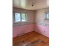 Bedroom with wood floor, light pink walls with unicorn wallpaper border and natural lighting from two windows at 8250 Ralph Ln, Denver, CO 80221