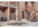 Exterior view of a condo with wood siding, rock landscaping, stairs, and a small patio at 540 S Forest St # 7-102, Denver, CO 80246