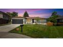Charming one-story home with a well-maintained lawn, mature trees, and an attached garage in a suburban neighborhood at 1354 S Wright St, Lakewood, CO 80228