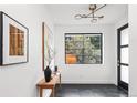 Bright entryway featuring tiled floors, stylish light fixture, window view, and decorative wall art at 2522 Zenobia St, Denver, CO 80212