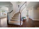 Grand foyer featuring a curved staircase with wood railing and hardwood floors at 11506 Greenbriar Ln, Parker, CO 80138
