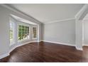 Bright living room with hardwood floors, crown molding, and a large bay window at 11506 Greenbriar Ln, Parker, CO 80138