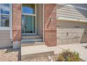 Charming front entrance with a teal door, brick accents, and a well-maintained walkway at 22436 E Maplewood Pl, Aurora, CO 80015