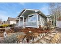 Side view of a well-maintained home showcasing the inviting front porch and lovely landscaping at 742 Megan Ct, Longmont, CO 80504