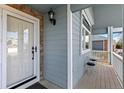 Inviting front porch featuring a sitting area, a storm door, and elegant exterior lighting at 742 Megan Ct, Longmont, CO 80504
