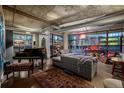 Spacious living room with large windows, a piano, and an open, industrial-style ceiling at 2100 16Th St # 412, Denver, CO 80202