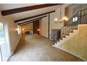 Bright living room showcasing beamed ceilings, a cozy fireplace, and a staircase at 8450 Mason Cir, Westminster, CO 80031