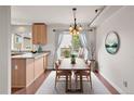 Open dining area with modern lighting, wood floors, and view of outdoor entertaining space with swing at 3312 Meadow Ave, Broomfield, CO 80020