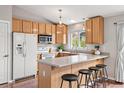 Bright kitchen with wood cabinets, stainless steel appliances, quartz counters, and island seating at 3312 Meadow Ave, Broomfield, CO 80020