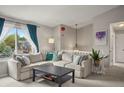 Bright living room with large sectional, window, gray walls, and plush carpet at 3312 Meadow Ave, Broomfield, CO 80020
