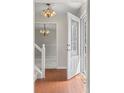 Bright foyer featuring tiled floor, modern chandelier, and decorative glass door leading to other rooms at 1487 W Fair Ave, Littleton, CO 80120