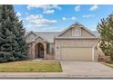 Charming brick home with a well-maintained lawn and attached two-car garage under blue skies at 5322 Shetland Ct, Highlands Ranch, CO 80130