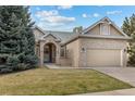 Charming brick home with a well-maintained lawn and attached two-car garage on a sunny day at 5322 Shetland Ct, Highlands Ranch, CO 80130