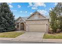 Charming brick home with a well-maintained lawn and attached two-car garage with blue skies at 5322 Shetland Ct, Highlands Ranch, CO 80130