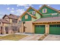 Beautiful two-story home with green and tan exterior, two-car garage, and landscaping at 11932 W Long Cir # 201, Littleton, CO 80127