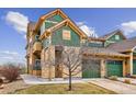 Tan and green two-story home with two-car garage and landscaping at 11932 W Long Cir # 201, Littleton, CO 80127