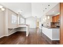 Open concept kitchen and living room with hardwood floors, island, and fireplace at 11932 W Long Cir # 201, Littleton, CO 80127