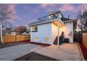 Exterior featuring a rooftop deck, well-lit patio, and a fenced yard, set against a beautiful twilight sky at 2767 W 38Th Ave, Denver, CO 80211